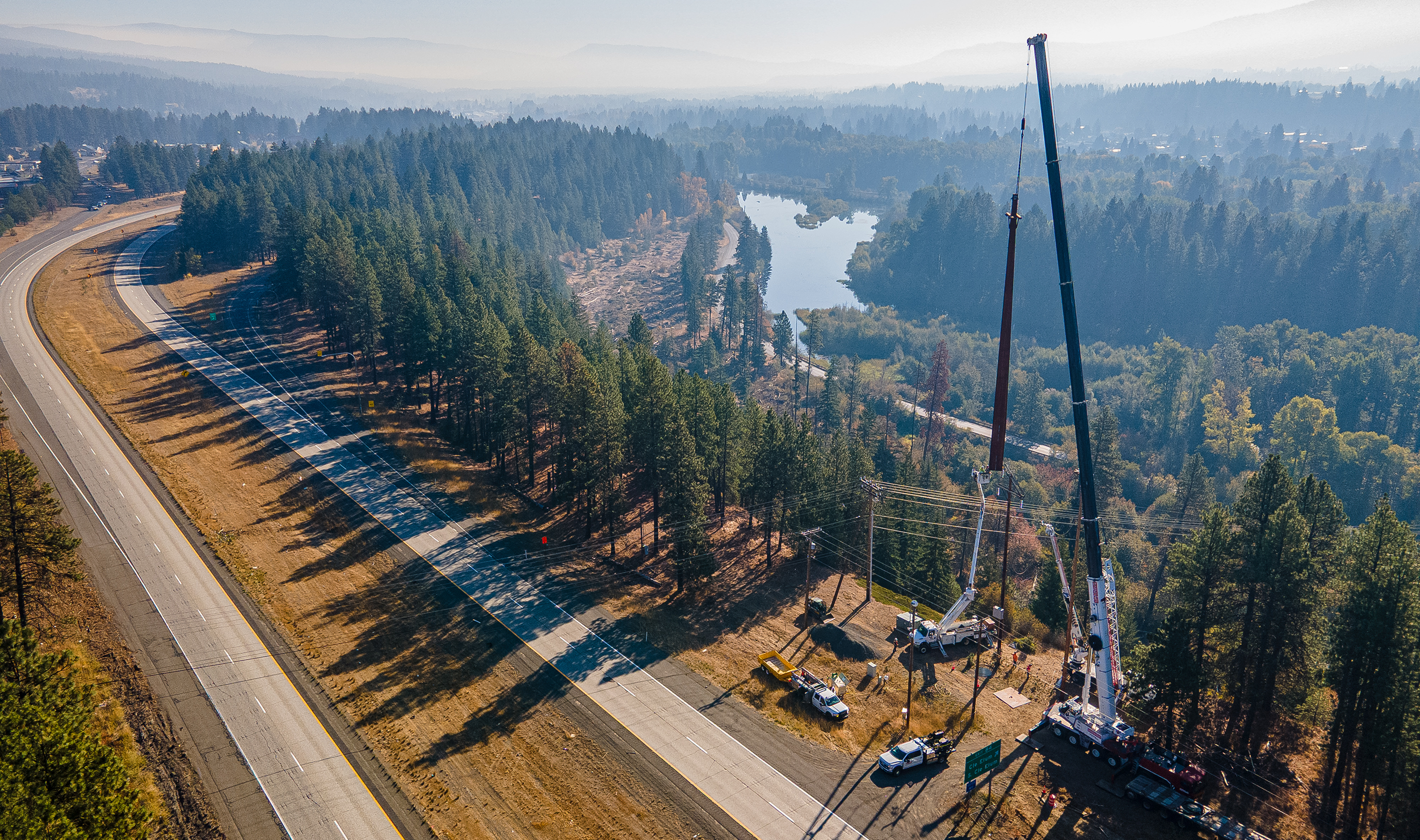 Aerial view of a crane lowering a pole into place