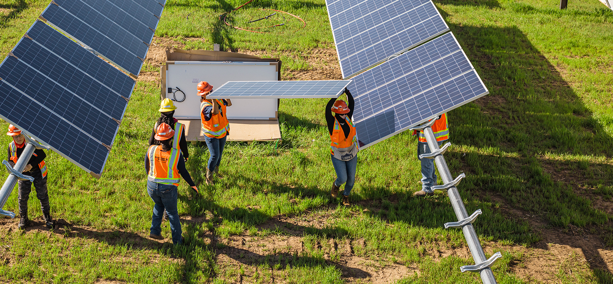 Team installing solar panels in a field