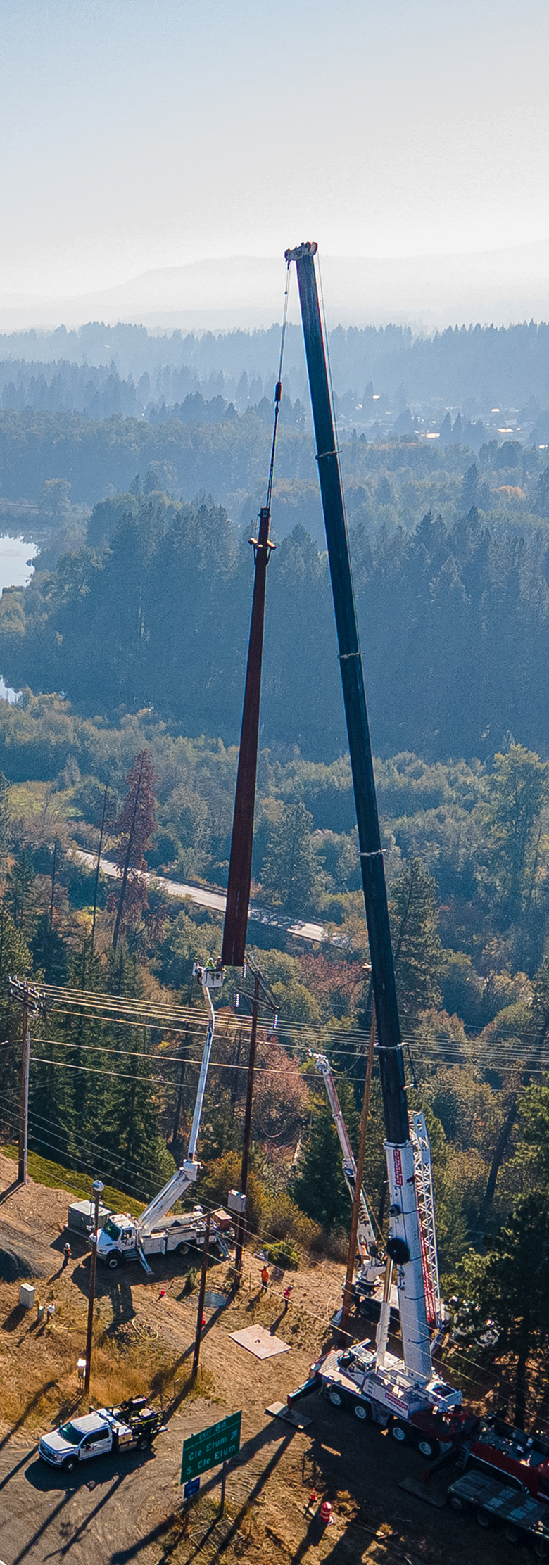Aerial view of a crane lowering a pole into place